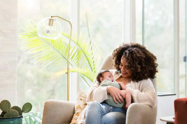 blog-2 A woman holding her baby in the arms of another person.